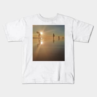 Silhouetted people in a row on a sand beach. Kids T-Shirt